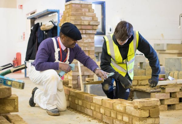 Student and teacher working on bricklaying