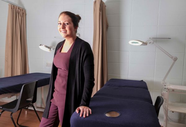 Beauty student stood by message beds