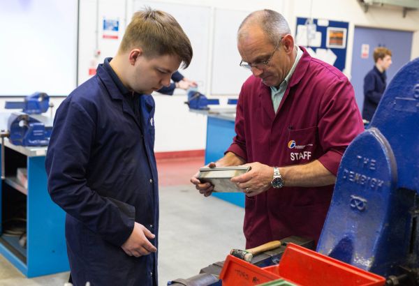 Male engineering student and lecturer working with engineering equipment