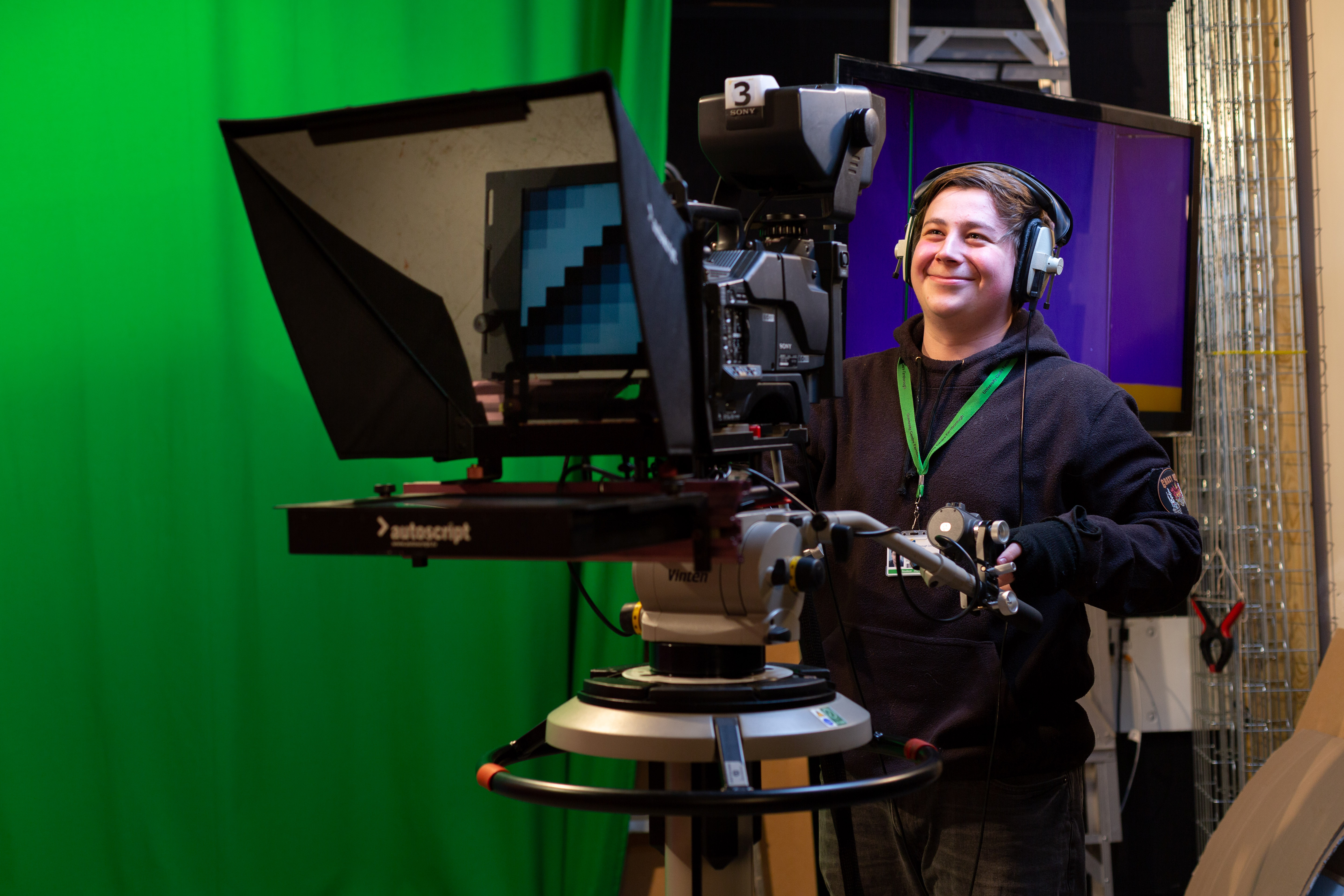 student-using-filming-equipment-in-tv-studio