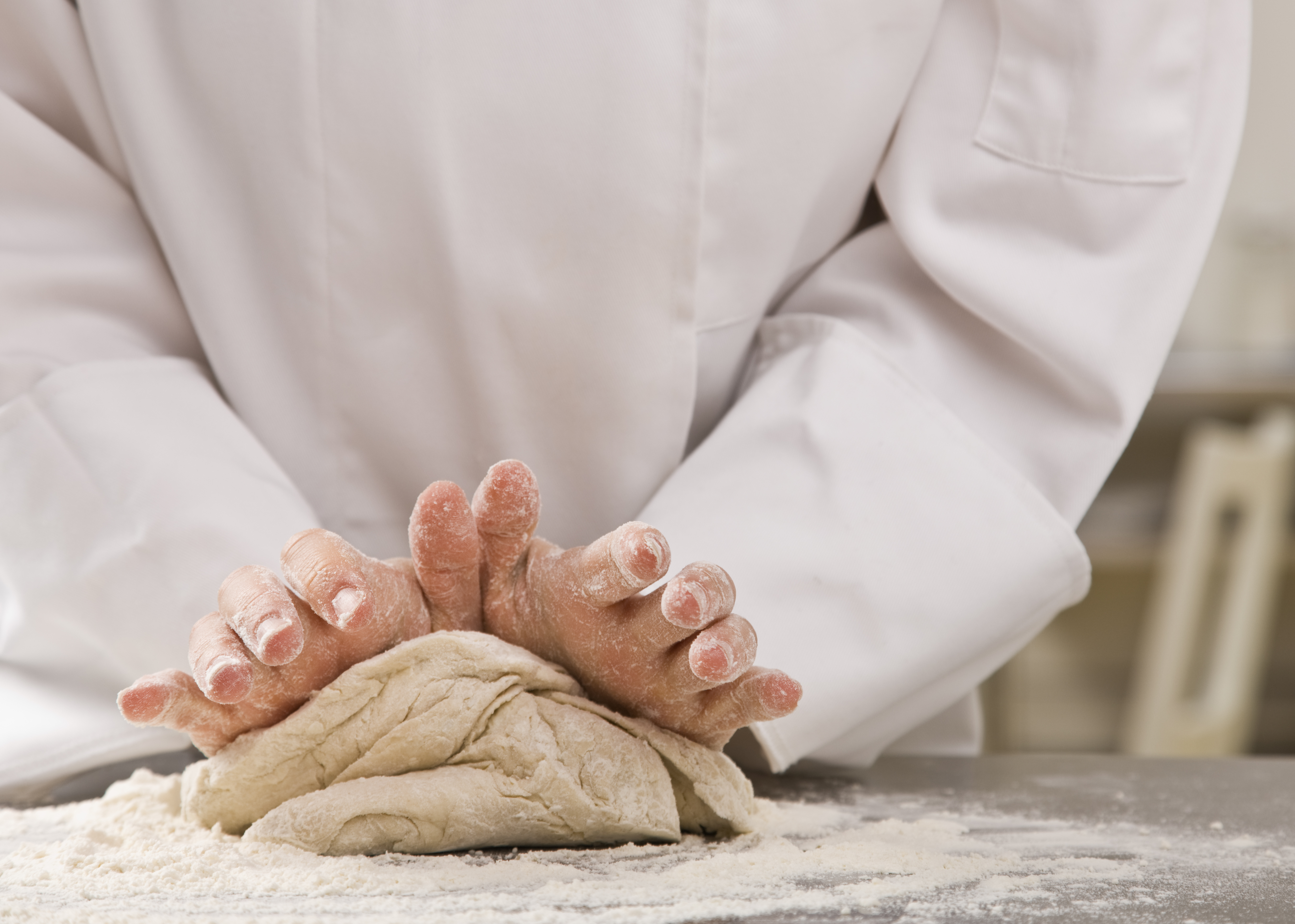 Chef kneeding dough 
