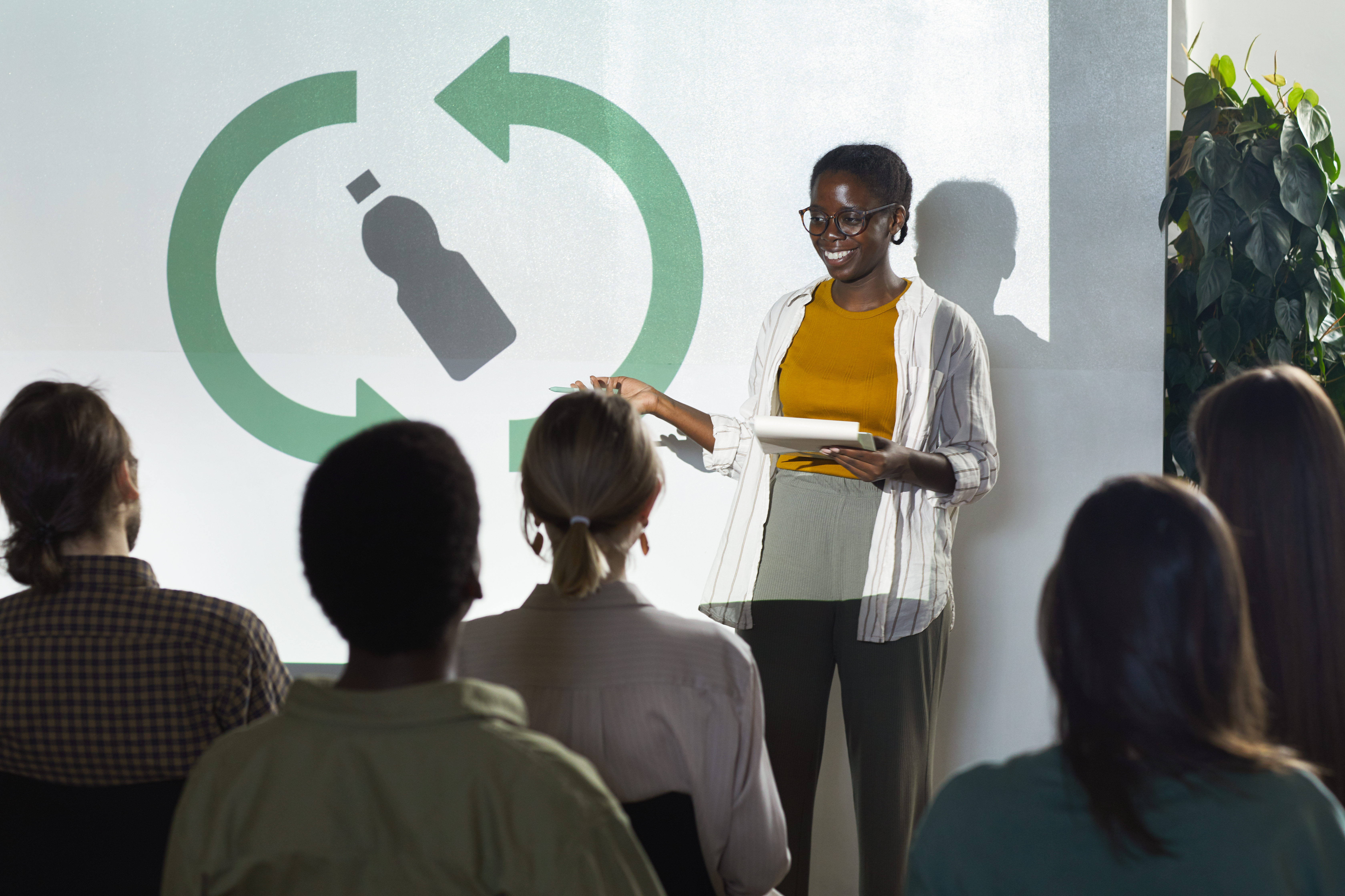 Woman stands giving a presentation on Environmental Sustainability