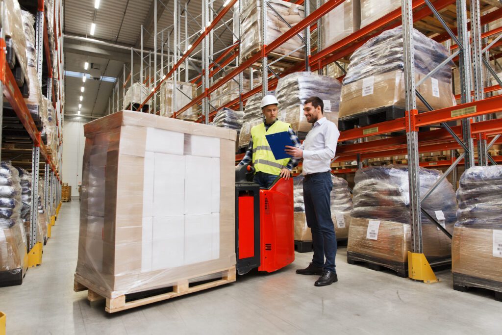 Supervisor stands with employee in warehouse environment