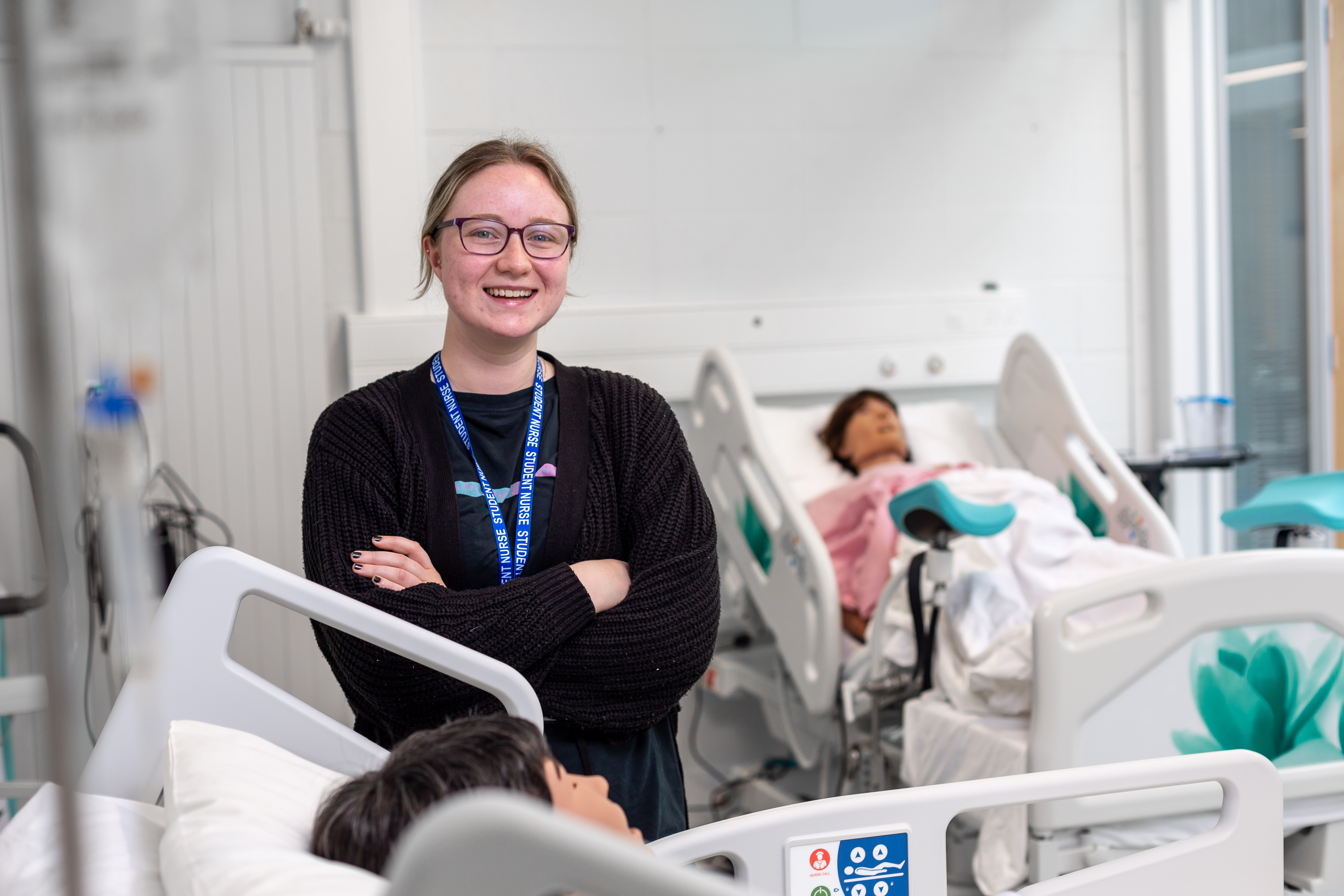 Health and social care student stood by bed in our Medtech Centre